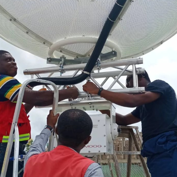 Technicians installing a satellite ground-station antenna